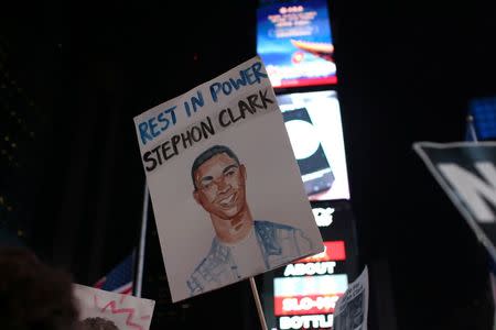 Protesters hold up an illustration as they march in Times Square in the Manhattan borough of New York City, during a protest against the death of Stephon Clark in Sacramento, California, U.S. March 28, 2018. REUTERS/Gabriela Bhaskar