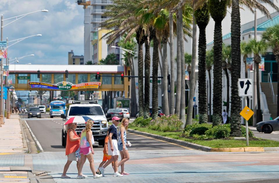 A group of pedestrians cross Atlantic Avenue in Daytona Beach, Monday, July 11, 2022. 