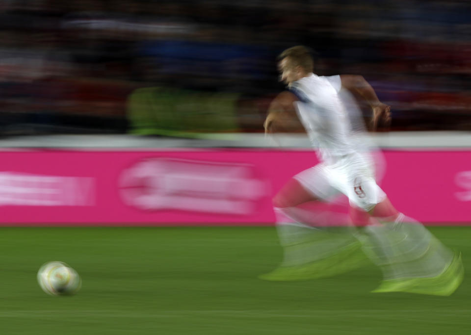 FILE - In this Oct. 11, 2019, file image taken with a slow shutter speed a soccer player runs for the ball during the Euro 2020 group A qualifying soccer match in Prague, Czech Republic. A study, from the University of Glasgow and reported Monday, Oct. 21, in New England Journal of Medicine, of former professional soccer players in Scotland found that they were less likely to die of common causes such as heart disease and cancer compared with the general population but more likely to die from dementia. (AP Photo/Petr David Josek, File)