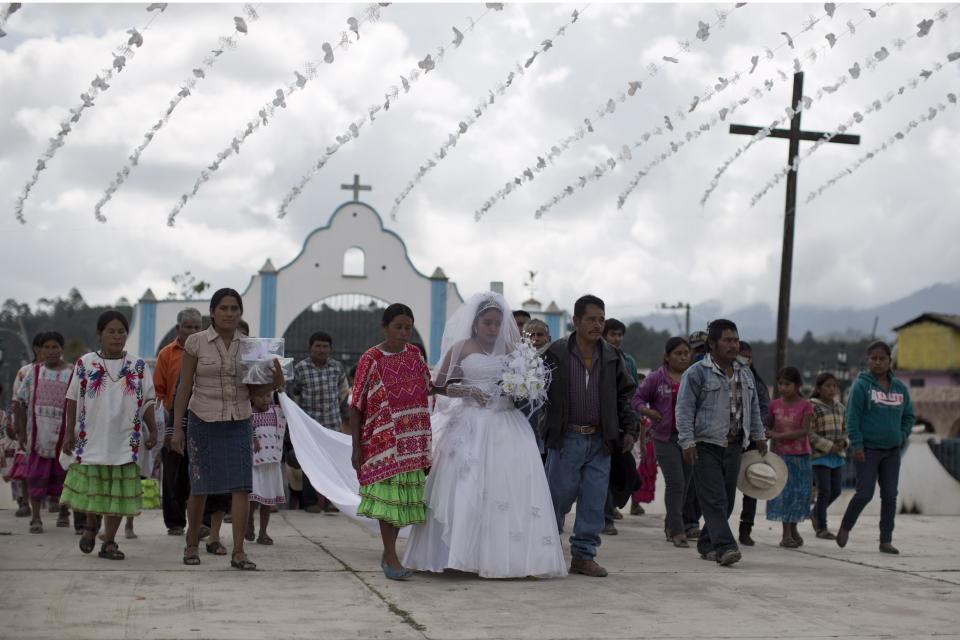 In this Feb. 11, 2014 photo, a bride is accompanied by her relatives and friends as she arrives at the church in Cochoapa El Grande, Mexico. In the 400 poorest and most malnourished of the country’s 2,400 municipalities that includes Cochoapa, the administration of Enrique Pena Nieto has been trying to enroll more people in existing social programs such as Opportunities, which provides a small monthly stipend to qualifying poor Mexicans. (AP Photo/Dario Lopez-Mills)