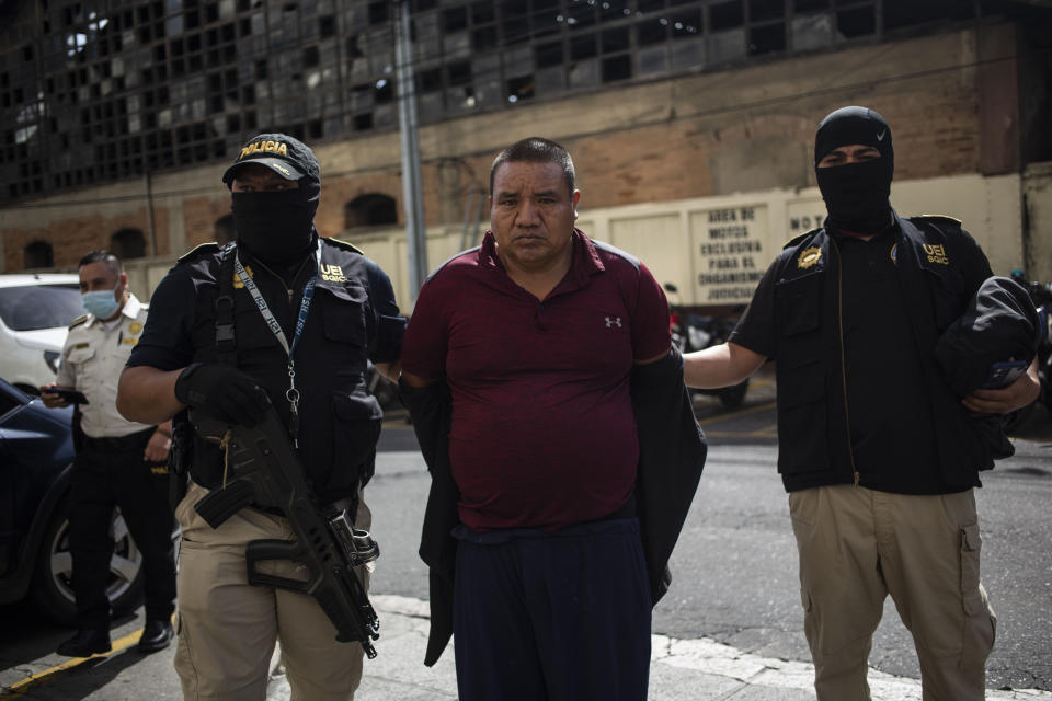 Juan Gutiérrez Castro es escoltado con esposas a la corte tras ser detenido durante una operación policial contra presuntos traficantes de migrantes en la Ciudad de Guatemala, el martes 2 de agosto de 2022. (Foto AP/Oliver de Ros)