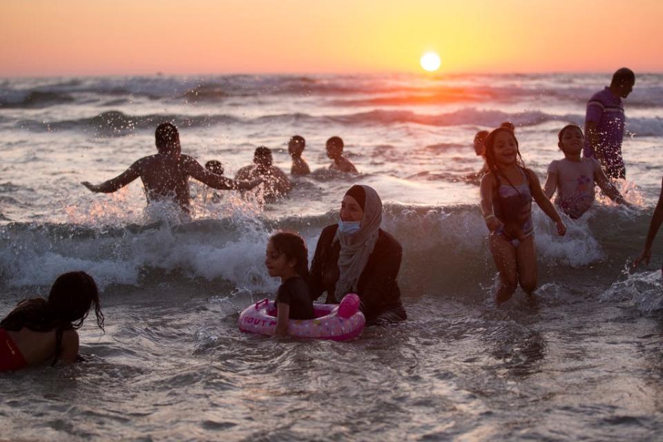 People enjoy the mediterranean sea during the Eid al-Adha holiday in Tel Aviv's beach, Israel, Sunday, Aug. 2, 2020.