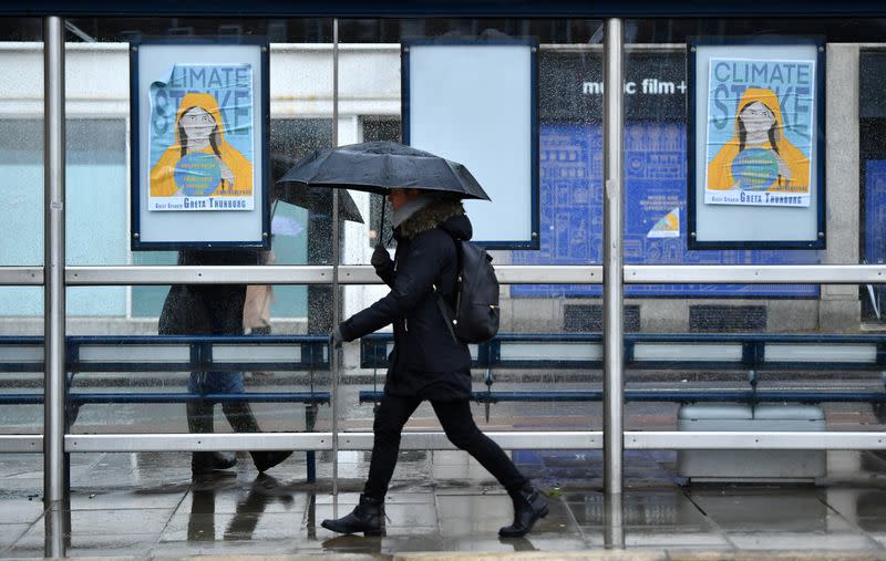 A woman walks past banners, ahead of a youth climate protest in Bristol