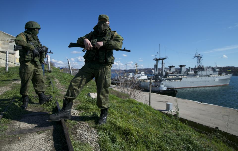 FILE - Russian soldiers guard a pier where two Ukrainian naval vessels are moored, in Sevastopol, Ukraine, on Wednesday, March 5, 2014. When Ukraine's Kremlin-friendly president was ousted in 2014 by mass protests that Moscow called a U.S.-instigated coup, Russian President Vladimir Putin responded by sending troops to overrun Crimea and staging a plebiscite on joining Russia, which the West dismissed as illegal. (AP Photo, File)