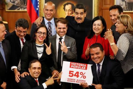 Venezuela's President Nicolas Maduro poses for a picture with new elected governors after a news conference at Miraflores Palace in Caracas, Venezuela October 17, 2017. The placard reads, "Popular victory, 54%, we are joy, we are majority". REUTERS/Carlos Garcia Rawlins