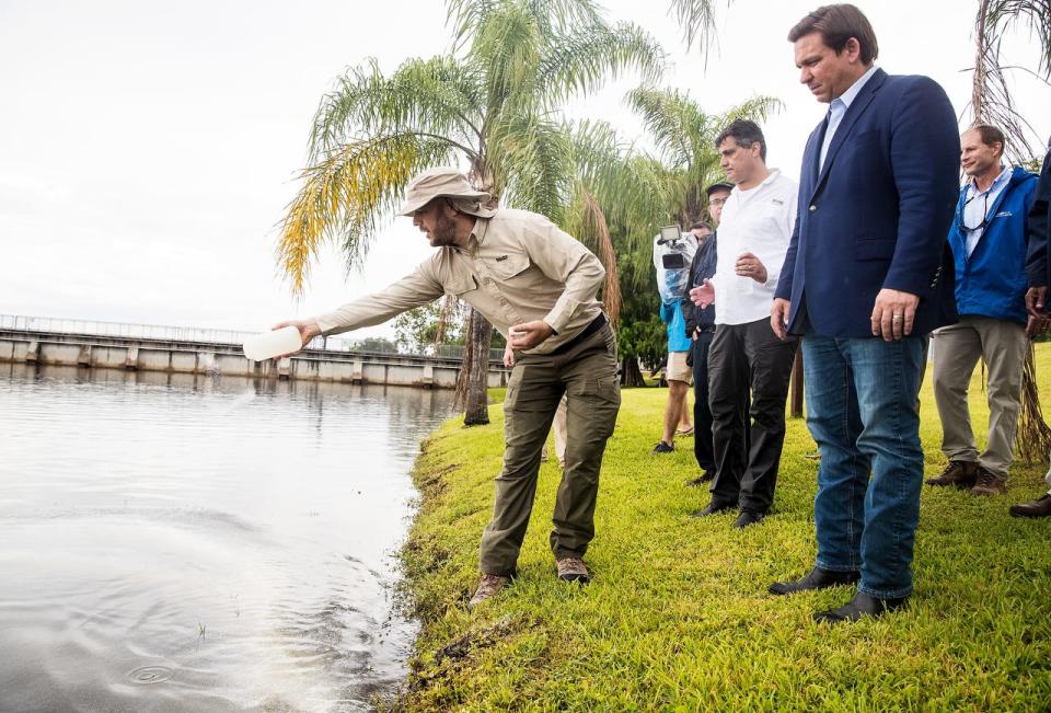 Eyal Harel, the CEO of Blue Green Water Technologies gives a demonstration on how his product, Lake Guard Oxy removes blue green algae for Gov. Ron DeSantis at the Franklin Locks in Olga on Thursday, June, 3, 2021. 