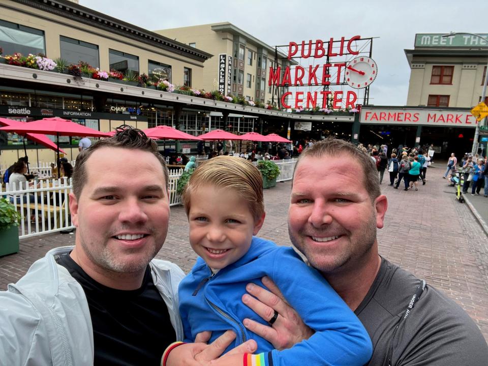 Robby Price, left, and Jordan Letschert, right, with their son, Kellen Letschert-Price, visited Pike Place Market in Seattle while on vacation. 