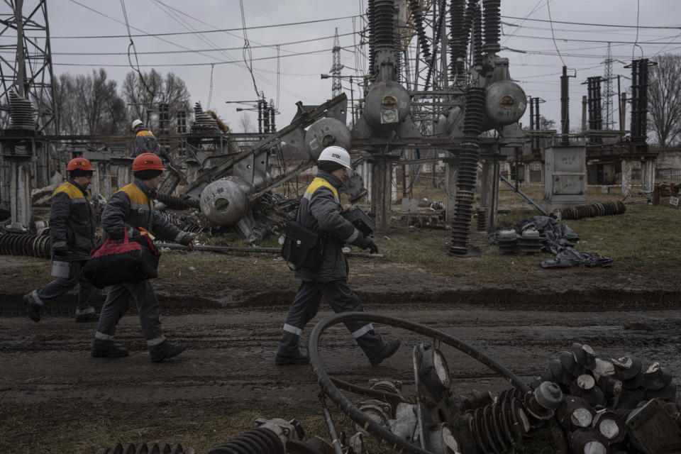 Power plant workers walk to repair damages after a Russian attack in central Ukraine, Thursday, Jan. 5, 2023. When Ukraine was at peace, its energy workers were largely unheralded. War made them heroes. They're proving to be Ukraine's line of defense against repeated Russian missile and drone strikes targeting the energy grid and inflicting the misery of blackouts in winter. (AP Photo/Evgeniy Maloletka)