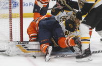 Boston Bruins goaltender Tuukka Rask (40) makes the save as Edmonton Oilers' Ryan Nugent-Hopkins (93) falls on top of him during the second period of an NHL hockey game, Wednesday, Feb. 19, 2020 in Edmonton, Alberta. (Jason Franson/The Canadian Press via AP)