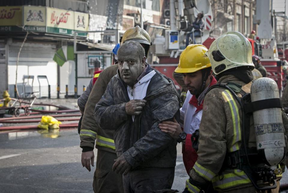 <p>Ein verletzter Mann wird von Rettungskräften versorgt. Mindestens 30 Menschen wurden beim Einsturz eines 17-stöckigen Gebäudes in Teheran, Iran, getötet. (Bild: Ahmad Halabisaz/ Xinhua via Zuma Wire) </p>