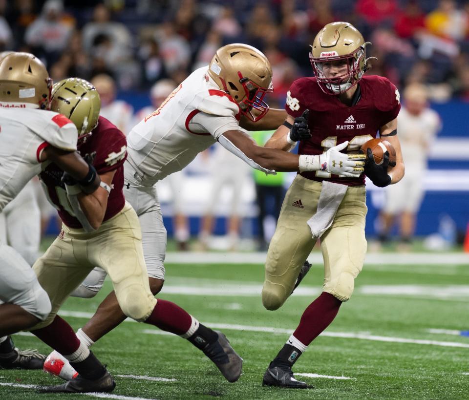 Mater Dei's Eli McDurmon (12) rushes with the ball during the IHSAA Class 2A football state championship between the Mater Dei Wildcats and the Andrean Fighting 59ers at Lucas Oil Stadium in Indianapolis, Ind., Saturday afternoon, Nov. 27, 2021.