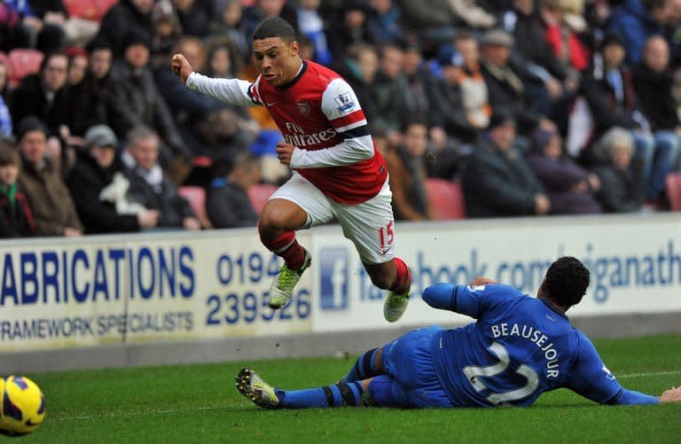 Wigan Athletic's midfielder Jean Beausejour (R) tackles Arsenal's midfielder Alex Oxlade-Chamberlain during their English Premier League football match at The DW Stadium in Wigan, north-west England on December 22, 2012. Arsenal won 1-0