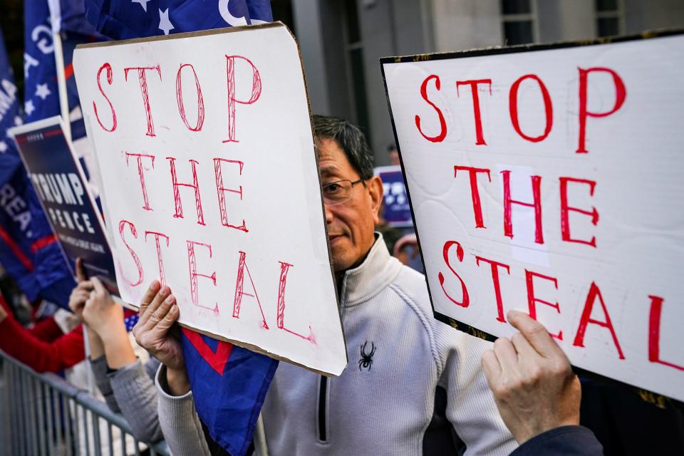 Supporters of President Donald Trump hold up signs in Philadelphia.