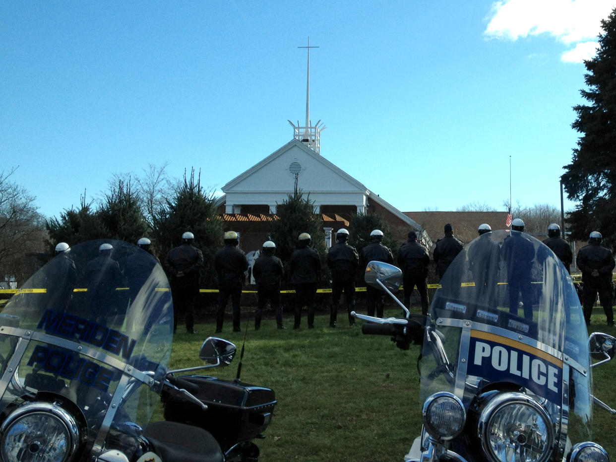 A line of police officers stand outside a funeral service for victims of the Sandy Hook shooting.