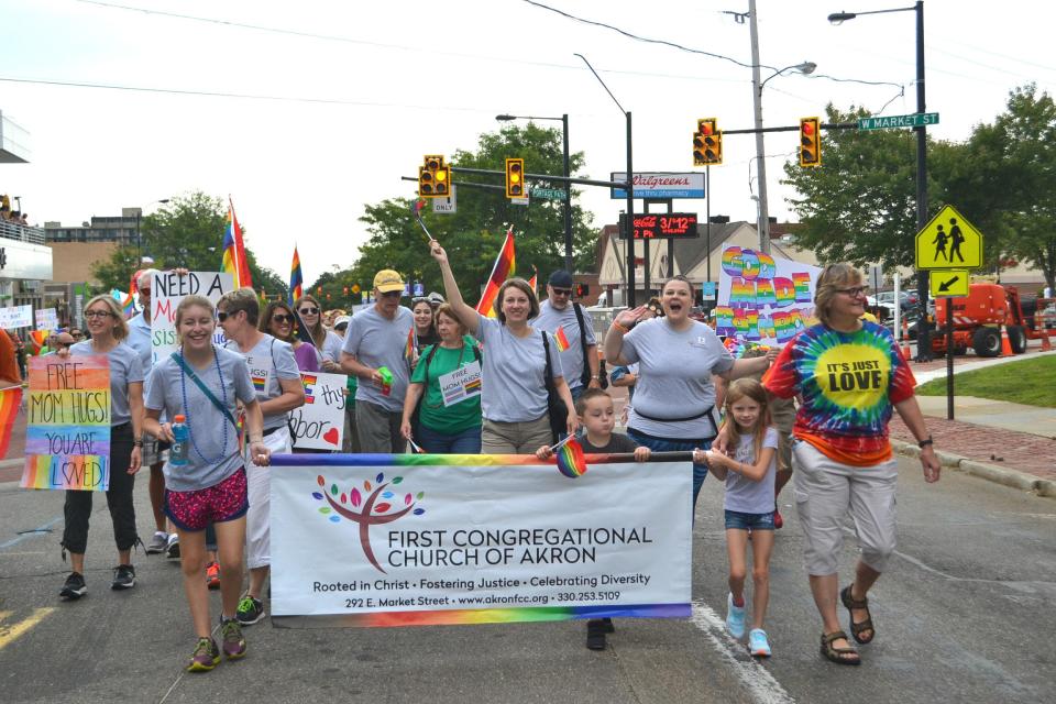 Nanette Pitt walks through Highland Square with members of First Congregational Church during the city's Pride festival.