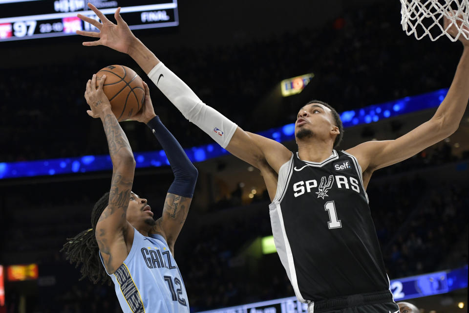 Memphis Grizzlies guard Ja Morant (12) shoots against San Antonio Spurs center Victor Wembanyama (1) in the second half of an NBA basketball game Tuesday, Jan. 2, 2024, in Memphis, Tenn. (AP Photo/Brandon Dill)