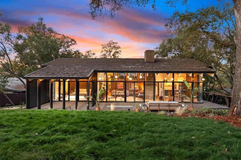 The Carter Sparks-designed mid-century modern home in Fair Oaks, California, has floor-to-ceiling windows looking in from the backyard.