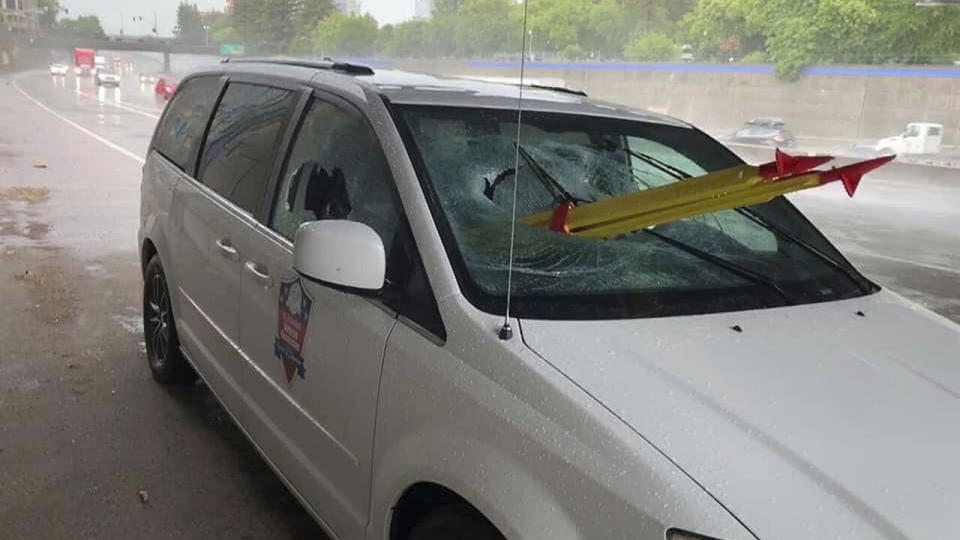 A car sits on the edge of a Cailfornian highway with a stolen tripod through its windscreen.