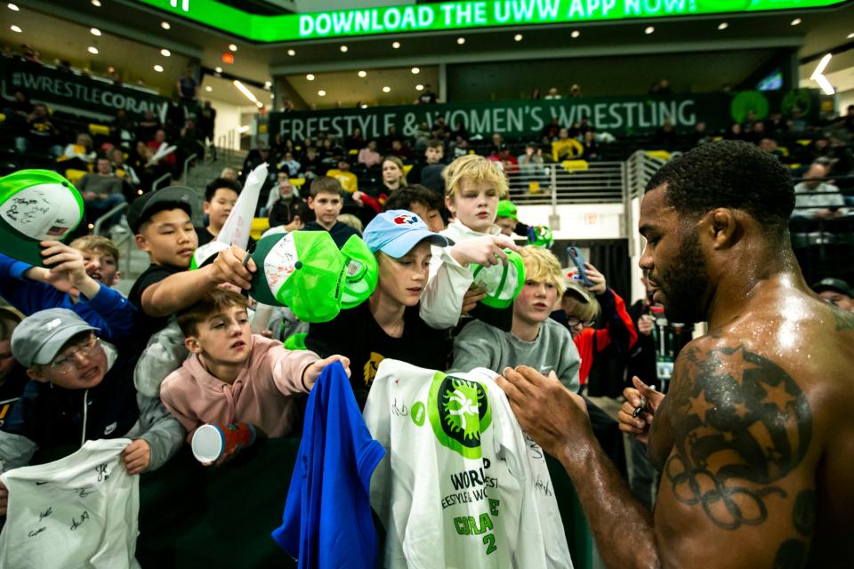 Jordan Burroughs of the United States signs autographs for fans after winning a decision at 79 kg during the United World Wrestling men's freestyle World Cup, Saturday, Dec. 10, 2022, at Xtream Arena in Coralville, Iowa. 