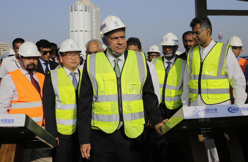 FILE - Then Sri Lankan Prime Minister Ranil Wickremesinghe, center, watches the land that was reclaimed from the Indian Ocean for the Colombo Port City project, part of China's One Belt One Road Initiative, on the Galle Face sea promenade in Colombo, Sri Lanka, on Jan. 2, 2018. Sri Lanka's new President Ranil Wickremesinghe, who took office in July, is attending the forum as part of his first official trip to China. (AP Photo/Eranga Jayawardena, File)