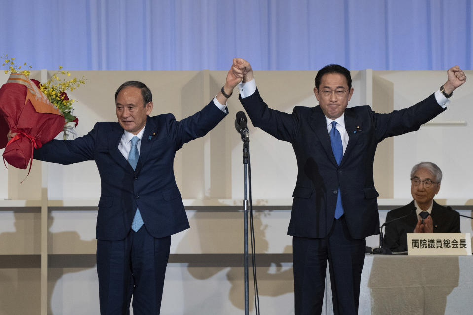 Japanese former Foreign Minister Fumio Kishida, right, celebrates with outgoing Prime Minister Yoshihide Suga after being announced the winner of the Liberal Democrat Party leadership election in Tokyo Wednesday, Sept. 29, 2021. Kishida won the governing party leadership election on Wednesday and is set to become the next prime minister, facing the imminent task of addressing a pandemic-hit economy and ensuring a strong alliance with Washington to counter growing regional security risks. (Carl Court/Pool Photo via AP)