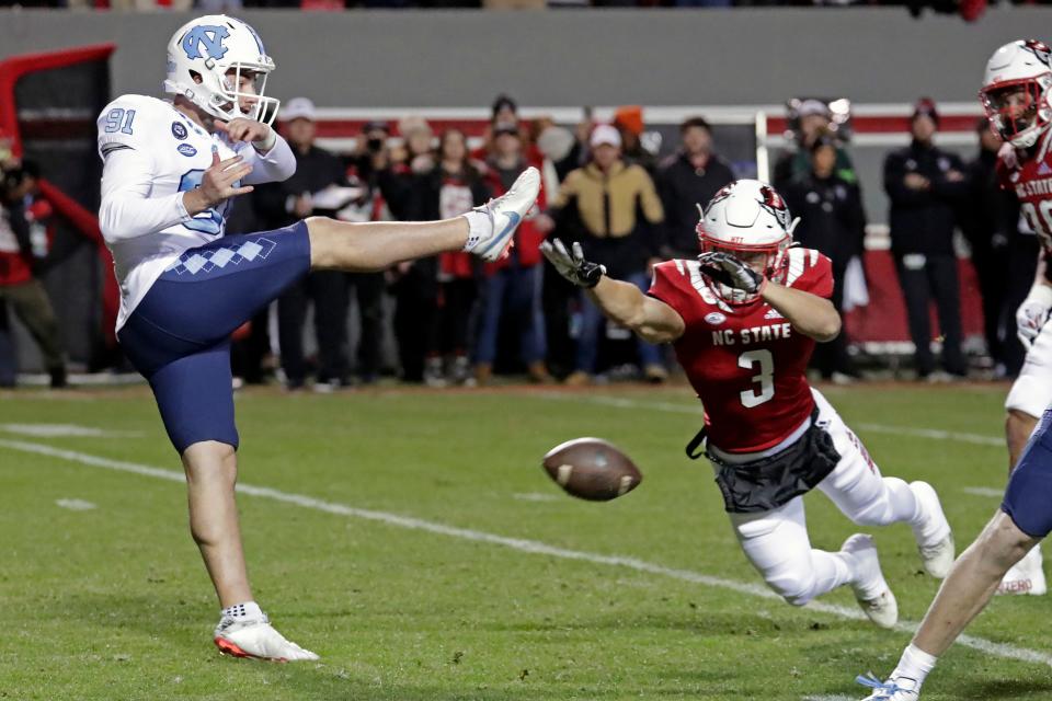 N.C. State’s Jordan Houston blocks a punt by North Carolina’s Ben Kiernan on Friday night. The Wolfpack recovered for a touchdown.