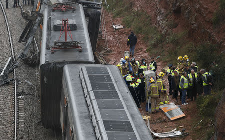 Firefighters, police and other officials survey the scene after a commuter train derailed between Terrassa and Manresa, outside Barcelona, Spain, November 20, 2018. REUTERS/Albert Gea