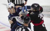 Ottawa Senators defenseman Josh Brown lands a punch on Winnipeg Jets defenseman Logan Stanley during first-period NHL hockey game action Monday, April 12, 2021, in Ottawa, Ontario. (Adrian Wyld/The Canadian Press via AP)