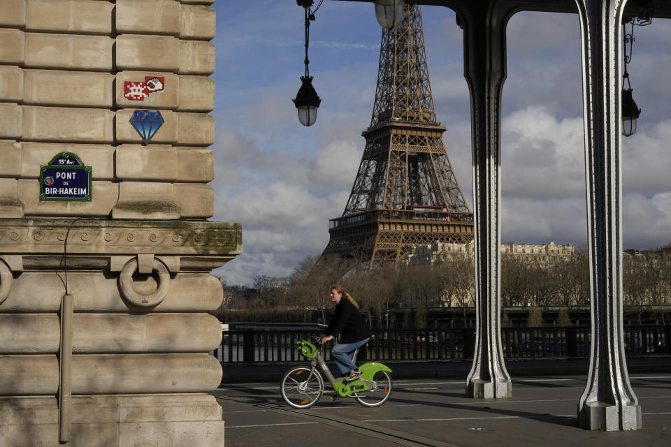 A mosaic by French artist Invader, in red top left, is seen on a street of Paris, near the Eiffel Tower, Friday, March 1, 2024. For the Paris Olympics, it could almost have been a new sport: Score points by scouring France's capital for mosaics that a mystery artist who calls himself "Invader" has cemented to walls across the city, across the world and even had carried aloft to the International Space Station. (AP Photo/Thibault Camus)