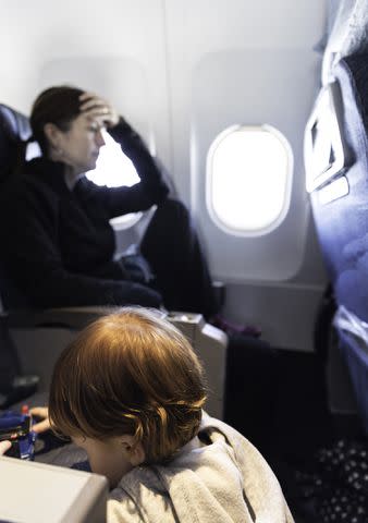 <p>Getty Images</p> A stock photo of a woman traveling with a child on an airplane