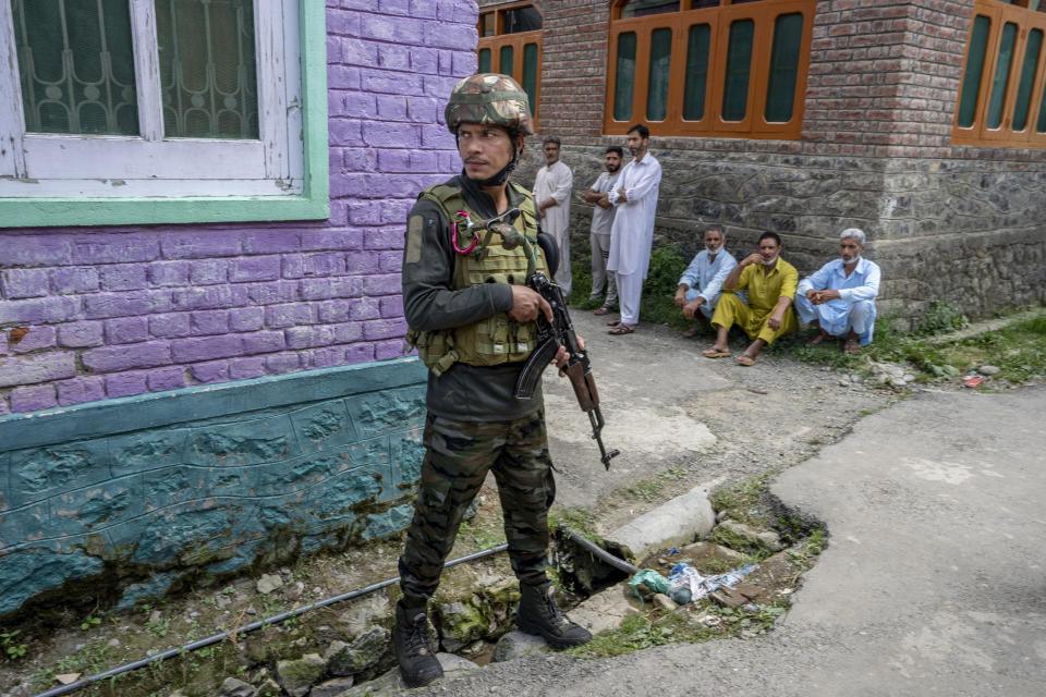 An Indian army soldier stands guard outside the house of his colleague Waseem Sarvar Bhat, who was killed in a gun battle with suspected rebels, as relatives and villagers wait for the body to arrive in Bandipora, north of Srinagar, Indian controlled Kashmir, Saturday, Aug. 5, 2023. Three Indian soldiers were killed in a gunbattle with rebels fighting against New Delhi's rule in Kashmir, officials said Saturday, as authorities stepped up security on the fourth anniversary since India revoked the disputed region's special status.(AP Photo/Dar Yasin)