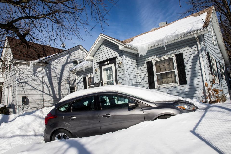 A car remains plowed in at West 4th and Raspberry streets on Feb. 7, 2022, in Erie. 