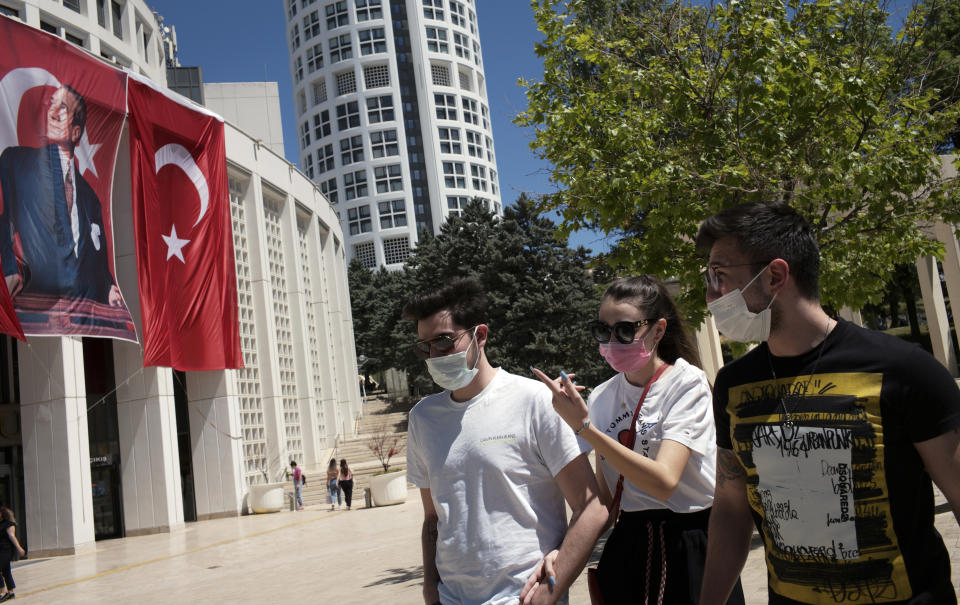 People wearing masks to help protect against the spread of coronavirus, walk in Ankara, Turkey, Thursday, May 20, 2021. Turkey's daily COVID-19 infections have dropped to levels last seen in mid-March as the country ended its strictest restrictions on Monday.(AP Photo/Burhan Ozbilici)