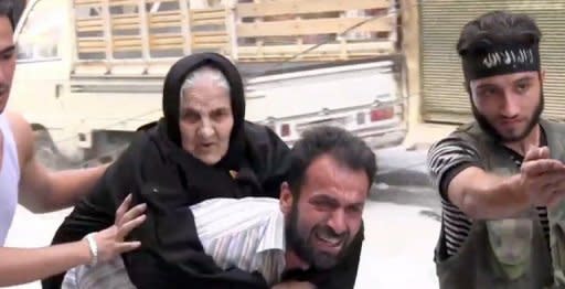 An image grab taken from AFPTV on August 7 shows a man evacuating an old Syrian woman from her house during clashes between rebel fighters and Syrian government forces in the Bustan al-Qasr district of the northern Syrian city of Aleppo. President Bashar al-Assad vowed on Tuesday to crush the 17-month rebellion against his regime and to cleanse Syria of "terrorists."