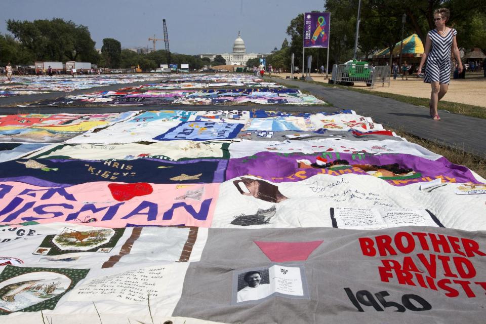 People visit the AIDS Memorial Quilt on display as part of the Smithsonian Folklife Festival on the National Mall in Washington, on Thursday, July 5, 2012. An AIDS-free generation: It seems an audacious goal, considering how the HIV epidemic still is raging around the world. Yet more than 20,000 international HIV researchers and activists will gather in the nation's capital later this month with a sense of optimism not seen in many years _ hope that it finally may be possible to stem the spread of the AIDS virus. (AP Photo/Jacquelyn Martin)