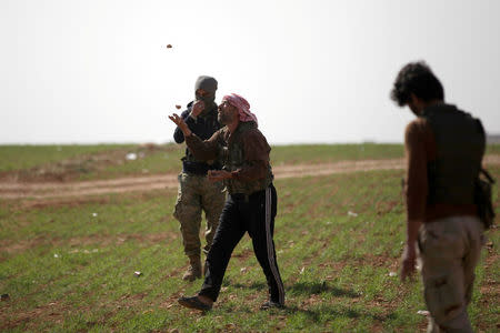 A rebel fighter juggles rocks east of al-Bab town, Syria March 9, 2017. REUTERS/Khalil Ashawi