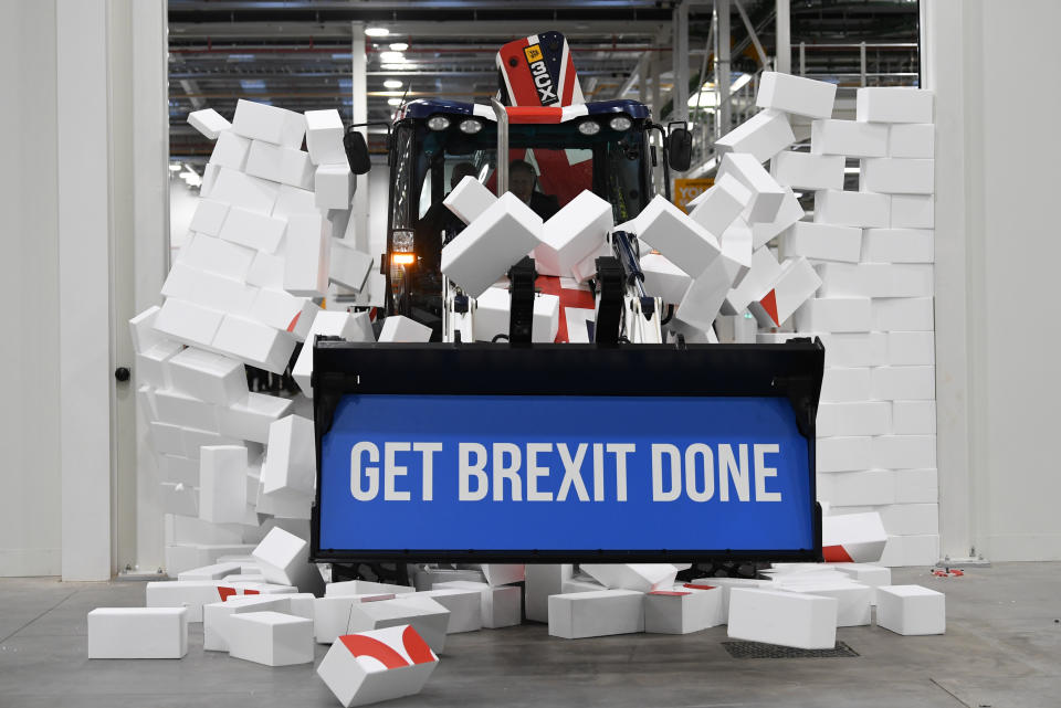 Prime Minister Boris Johnson drives a Union flag-themed JCB, with the words "Get Brexit Done" inside the digger bucket, through a fake wall emblazoned with the word "Gridlock", during a visit to JCB cab manufacturing centre in Uttoxeter, while on the General Election campaign trail.