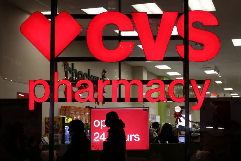 FILE PHOTO: People walk by a CVS pharmacy store in Manhattan, New York City