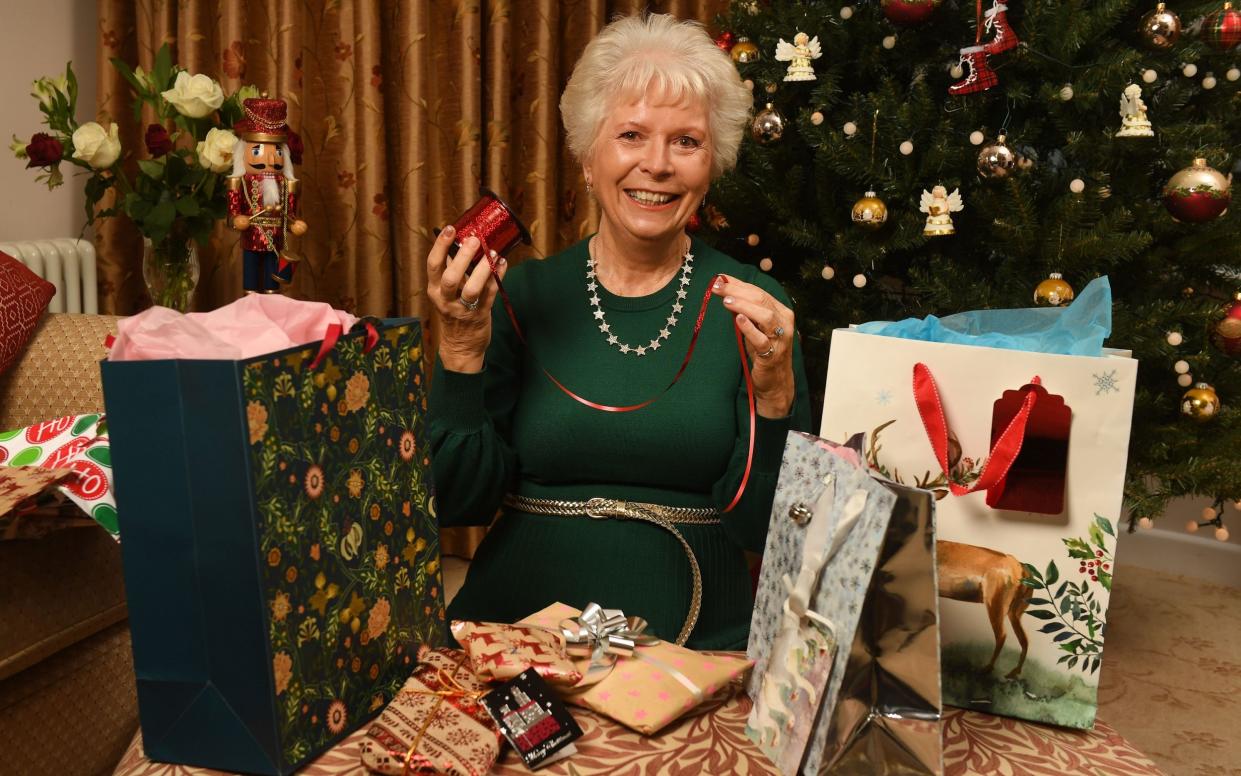 Christine Bourne smiling and posing with her Christmas presents