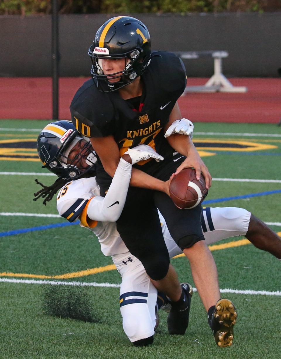 UPrep wide receiver Quantel Greene Jr. (15), left, tackles McQuaid punter Dominic Sansone (10) down near the goal line after the snap to Sansone went over his head, resulting in a turnover in the first half during their Section V matchup Friday night, Sept. 9, 2022 at McQuaid.
