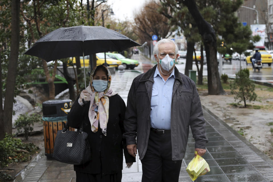 Pedestrians wear masks to help guard against the Coronavirus in downtown Tehran, Iran, Tuesday, Feb. 25, 2020. The head of Iran's counter-coronavirus task force has tested positive for the virus himself, authorities announced Tuesday, showing the challenges facing the Islamic Republic amid concerns the outbreak may be far wider than officially acknowledged. The announcement comes as countries across the Mideast say they’ve had confirmed cases of the virus that link back to Iran, which for days denied having the virus. (AP Photo/Ebrahim Noroozi)