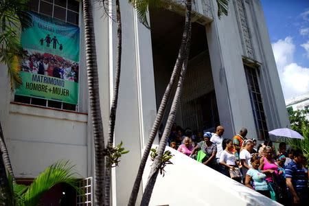 Worshippers leave a Methodist Church as a banner that reads in Spanish "I am in favour of the original design. The family as God created it. Wedding between man and woman", is displayed nearby in Havana, Cuba, October 2, 2018. REUTERS/Alexandre Meneghini