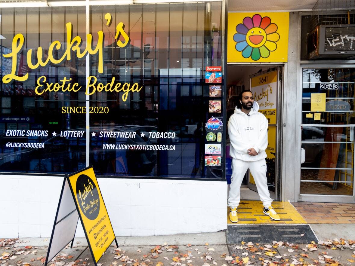 TJ Voss stands outside the first location of Lucky's Exotic Bodega in East Vancouver. Lucky’s Exotic Bodega sells hard-to-find snacks and drinks — as well as clothing — from around the world.  (Gian Paolo Mendoza/CBC - image credit)