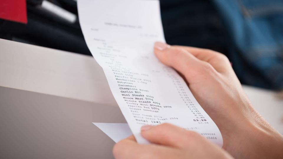 Cropped image of woman holding receipt in store