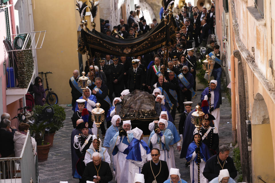 Authorities follow an 18th century wooden Christ before the start of a procession the in Procida Island, Italy, Friday, March 29, 2024. Italy is known for the religious processions that take over towns big and small when Catholic feast days are celebrated throughout the year. But even in a country where public displays of popular piety are a centuries-old tradition, Procida's Holy Week commemorations stand out. (AP Photo/Alessandra Tarantino)