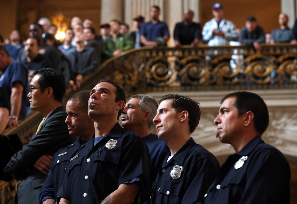 SAN FRANCISCO, CA - MARCH 26:  San Francisco firefighters look on during a remembrance ceremony held for San Francisco firefighters who have died of cancer on March 26, 2014 at San Francisco City Hall in San Francisco, California. Over two hundred pairs of boots were displayed on the steps inside San Francisco City Hall to symbolize the 230 San Francisco firefighters who have died of cancer over the past decade. According to a study published by the National Institute for Occupational Safety and Health, (NIOSH)  findings indicate a direct correlation between exposure to carcinogens like flame retardants and higher rate of cancer among firefighters.  The study showed elevated rates of respiratory, digestive and urinary systems cancer and also revealed that participants in the study had high risk of mesothelioma, a cancer associated with asbestos exposure.  (Photo by Justin Sullivan/Getty Images)