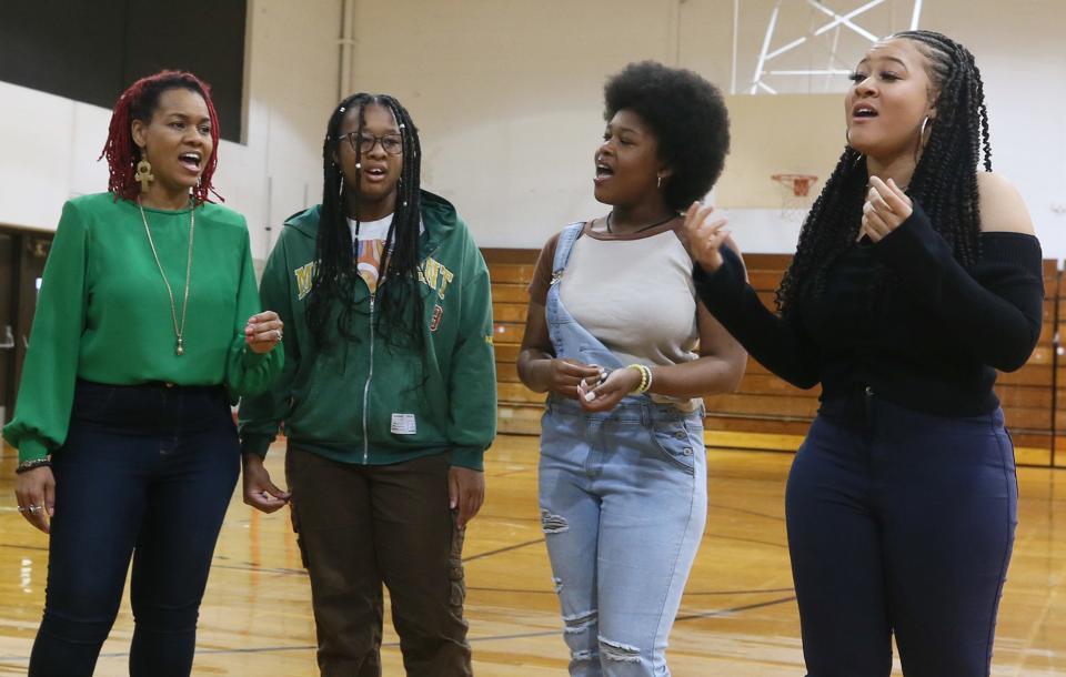 Serrin Joy, right,  sings with, from left, her mother Joy Scrutchings, sisters Lydia, 14, and Sophia, 12, in the gym at Miller South Thursday.