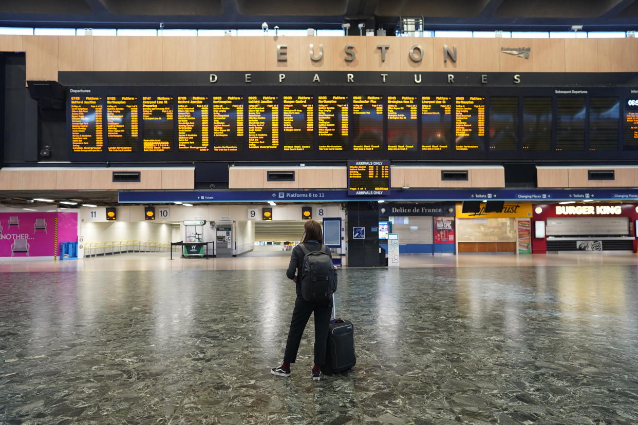 A passenger at Euston station in London looks at the departures board on the first day of a rail strike on Tuesday June 21, 2022. Britain's biggest rail strikes in decades went ahead Tuesday after last-minute talks between a union and train companies failed to reach a settlement over pay and job security. Up to 40,000 cleaners, signalers, maintenance workers and station staff are due to walk out for three days this week, on Tuesday, Thursday and Saturday. (Stefan Rousseau/PA via AP)