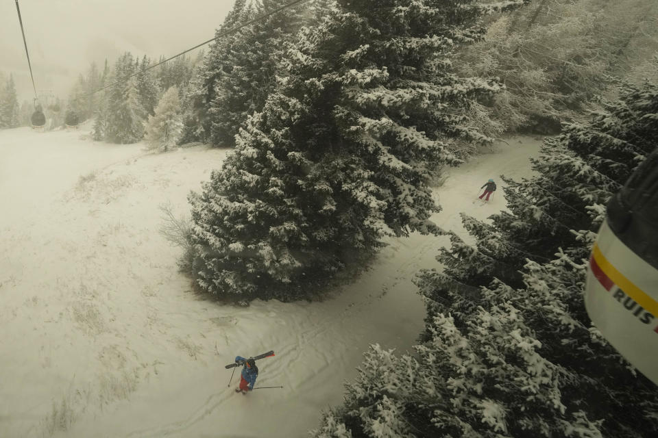 Tourists enjoy skiing at Plan de Corones ski area, Italy, Saturday, Nov. 27, 2021. After nearly two years of being restricted to watching snow accumulate on distant mountains, Italian skiers are finally returning to the slopes that have been off limits since the first pandemic lockdown in March 2020. But just as the industry is poised to recover from a lost 2020-2021 season after an abrupt closure the previous year, a spike in cases in the Alpine province bordering Austria is underlining just how precarious the situation remains. (AP Photo/Luca Bruno)