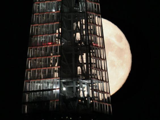 A full moon passes behind The Shard skyscraper on 9 September, 2014 in London, England (Getty Images)